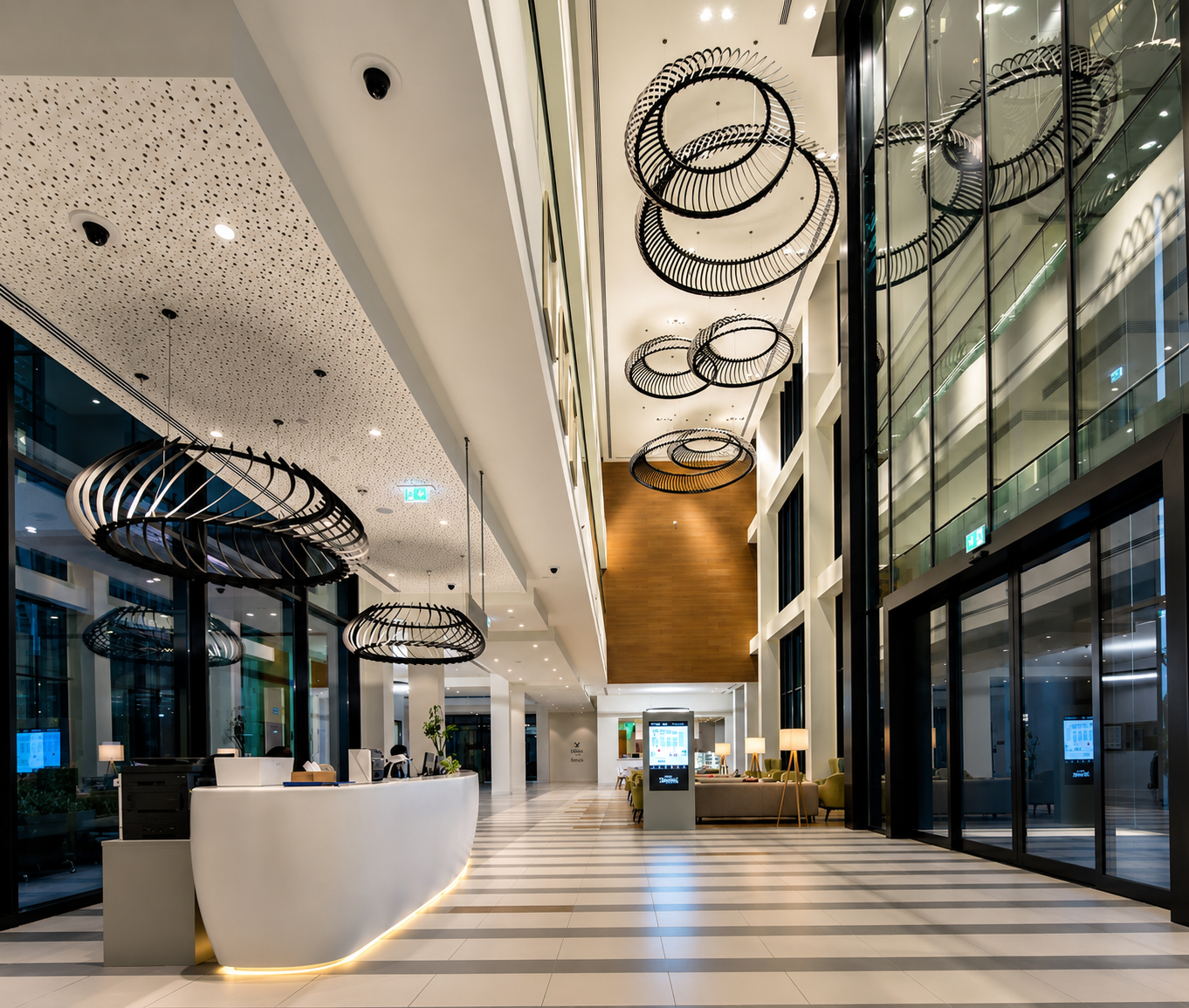 Double-height clinic atrium with sculptural pendant lighting and curved reception